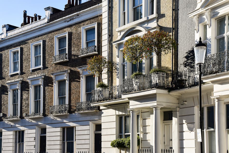 A row of elegant terraced homes on Marylebone High Street features classic British architecture with white and brick facades, tall sash windows, and ornate black wrought-iron balconies. The building i